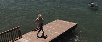 Movie still from “The Night House” (2020), directed by David Bruckner – A woman walking on a dock in the water; Extreme Wide shot, High angle