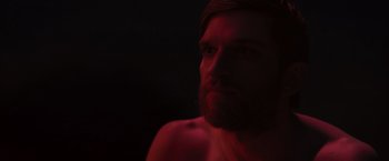 Movie still from “The Night House” (2020), directed by David Bruckner – A man with a beard is looking into the dark; Close Up shot, Low angle