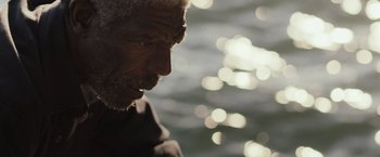 Movie still from “The Night House” (2020), directed by David Bruckner – An older man looking down at the water; Close Up shot, High angle