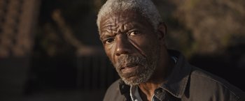 Movie still from “The Night House” (2020), directed by David Bruckner – An older man with a gray beard looking at the camera; Close Up shot, Low angle