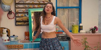 Movie still from “The Nightingale of Bursa” (2023), directed by Hakan Algül – A woman in white shirt and blue floral skirt dancing; Medium shot, Low angle