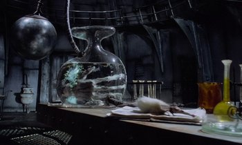 Movie still from “The Nightmare Before Christmas” (1993), directed by Henry Selick – A glass vase sitting on top of a wooden table; Wide shot, High angle