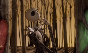 Movie still from “The Nightmare Before Christmas” (1993), directed by Henry Selick – A jack skellington figure in front of a forest; Medium shot, Low angle