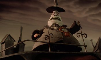 Movie still from “The Nightmare Before Christmas” (1993), directed by Henry Selick – A statue of a man with a hat on; Medium shot, Low angle