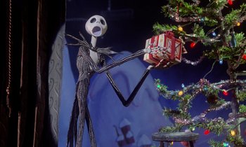Movie still from “The Nightmare Before Christmas” (1993), directed by Henry Selick – A jack skellington figure holding onto a christmas present; Medium shot, Low angle