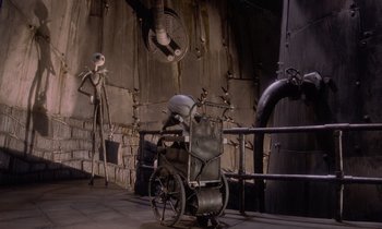 Movie still from “The Nightmare Before Christmas” (1993), directed by Henry Selick – A wheelchair in a room next to a wall; Wide shot, Low angle