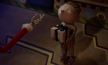 Movie still from “The Nightmare Before Christmas” (1993), directed by Henry Selick – A small toy figure holding a gift box; Medium shot, High angle