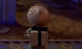 Movie still from “The Nightmare Before Christmas” (1993), directed by Henry Selick – A doll holding a gift box in its hands; Medium shot, Low angle