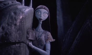 Movie still from “The Nightmare Before Christmas” (1993), directed by Henry Selick – A woman holding a knife next to a wall; Medium shot, Low angle