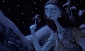 Movie still from “The Nightmare Before Christmas” (1993), directed by Henry Selick – A woman holding a flower in her hand in the snow; Medium shot, Low angle