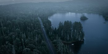 Movie still from “The Noel Diary” (2022), directed by Charles Shyer – An aerial view of a road and a body of water; Extreme Wide shot, High angle