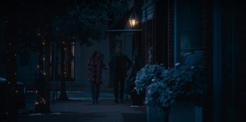 Movie still from “The Noel Diary” (2022), directed by Charles Shyer – A man and a woman walking down the sidewalk at night; Wide shot, Over the shoulder angle