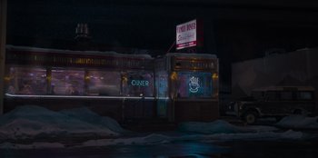 Movie still from “The Noel Diary” (2022), directed by Charles Shyer – A neon sign on the side of a diner in the dark; Extreme Wide shot, High angle