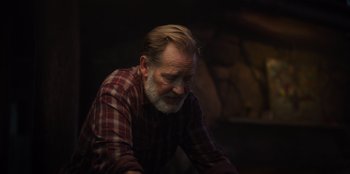 Movie still from “The Noel Diary” (2022), directed by Charles Shyer – An older man sitting in a dark room; Close Up shot, Over the shoulder angle
