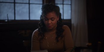 Movie still from “The Noel Diary” (2022), directed by Charles Shyer – A woman sitting at a table looking down at a piece of paper; Close Up shot, Over the shoulder angle