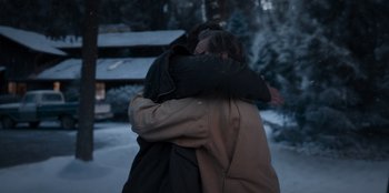 Movie still from “The Noel Diary” (2022), directed by Charles Shyer – Two people hugging in the snow near a house; Medium shot, Over the shoulder angle
