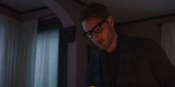Movie still from “The Noel Diary” (2022), directed by Charles Shyer – A man wearing glasses looking down at his cell phone; Close Up shot, Low angle