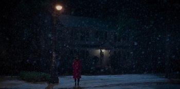 Movie still from “The Noel Diary” (2022), directed by Charles Shyer – A person standing in front of a street light at night; Extreme Wide shot, Over the shoulder angle