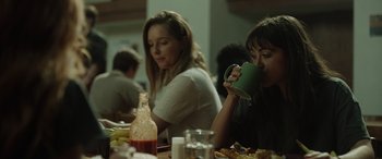 Movie still from “The Novice” (2021), directed by Lauren Hadaway – Two women are sitting at a table drinking coffee; Medium shot, Over the shoulder angle
