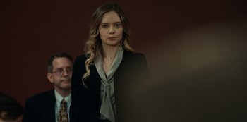 Movie still from “Dopesick” (2021), directed by Danny Strong – A woman in a black jacket and a man in a black suit; Medium shot, Over the shoulder angle