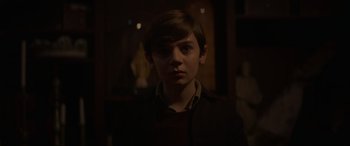 Movie still from “The Nun II” (2023), directed by Michael Chaves – A young boy is looking at the camera; Close Up shot, Over the shoulder angle