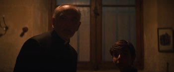 Movie still from “The Nun II” (2023), directed by Michael Chaves – A man and a boy standing next to each other in a room; Medium shot, Low angle