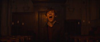 Movie still from “The Nun II” (2023), directed by Michael Chaves – A young boy with his mouth wide open; Medium shot, Low angle