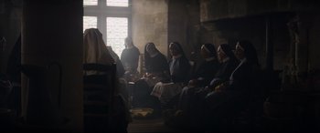 Movie still from “The Nun II” (2023), directed by Michael Chaves – A group of nuns sitting in a room with fruit; Wide shot, Low angle