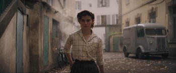 Movie still from “The Nun II” (2023), directed by Michael Chaves – A woman standing on a street with her hands in her pockets; Medium shot, Low angle