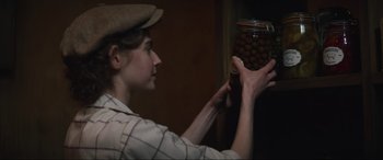 Movie still from “The Nun II” (2023), directed by Michael Chaves – A woman holding a jar filled with nuts; Close Up shot, Over the shoulder angle