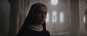 Movie still from “The Nun II” (2023), directed by Michael Chaves – A woman wearing a nun's outfit in a room; Close Up shot, Low angle