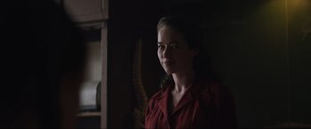 Movie still from “The Nun II” (2023), directed by Michael Chaves – A woman in a red shirt standing in front of a mirror; Close Up shot, Over the shoulder angle
