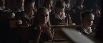 Movie still from “The Nun II” (2023), directed by Michael Chaves – A group of young people sitting at a desk; Medium shot, Over the shoulder angle