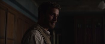 Movie still from “The Nun II” (2023), directed by Michael Chaves – A person with a beard wearing a vest; Close Up shot, Over the shoulder angle