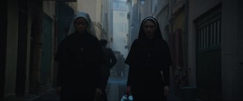 Movie still from “The Nun II” (2023), directed by Michael Chaves – Two nuns walking down a street in a dark city; Medium shot, Low angle