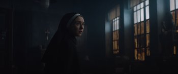 Movie still from “The Nun II” (2023), directed by Michael Chaves – A woman wearing a nun's habit in a dark room; Close Up shot, Low angle