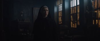 Movie still from “The Nun II” (2023), directed by Michael Chaves – A woman in a nun's outfit standing in a dark room; Medium shot, Low angle