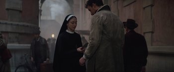 Movie still from “The Nun II” (2023), directed by Michael Chaves – A man and a woman are standing in a room; Medium shot, Over the shoulder angle