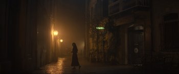 Movie still from “The Nun II” (2023), directed by Michael Chaves – A woman walking down the street at night in the fog; Extreme Wide shot, Low angle