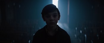 Movie still from “The Nun II” (2023), directed by Michael Chaves – A young boy is standing in a dark room; Close Up shot, High angle