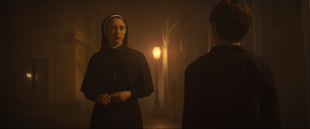Movie still from “The Nun II” (2023), directed by Michael Chaves – A woman wearing a nun's outfit standing in front of a mirror; Medium shot, Over the shoulder angle