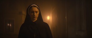 Movie still from “The Nun II” (2023), directed by Michael Chaves – A woman wearing a nun's habit with a cross on her head; Close Up shot, Low angle