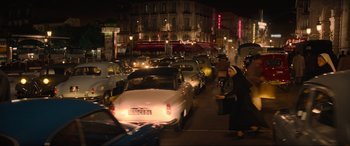 Movie still from “The Nun II” (2023), directed by Michael Chaves – A busy city street at night filled with lots of traffic; Extreme Wide shot, High angle