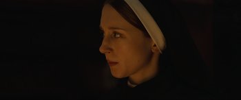 Movie still from “The Nun II” (2023), directed by Michael Chaves – A woman wearing a nun's outfit looking into the distance; Close Up shot, Low angle