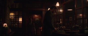 Movie still from “The Nun II” (2023), directed by Michael Chaves – A man and a woman preparing food in a dark room; Medium shot, Low angle