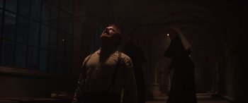 Movie still from “The Nun II” (2023), directed by Michael Chaves – A man standing in the dark with his mouth open; Wide shot, Low angle