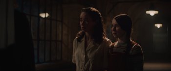 Movie still from “The Nun II” (2023), directed by Michael Chaves – Two women standing next to each other in a dark room; Medium shot, Over the shoulder angle