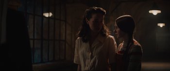 Movie still from “The Nun II” (2023), directed by Michael Chaves – Two women standing next to each other in a dark room; Medium shot, Over the shoulder angle