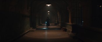 Movie still from “The Nun II” (2023), directed by Michael Chaves – A woman walking down a dark hallway with a flashlight in her hand; Extreme Wide shot, Low angle