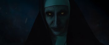Movie still from “The Nun II” (2023), directed by Michael Chaves – A nun with yellow eyes and a black robe; Close Up shot, Overhead angle